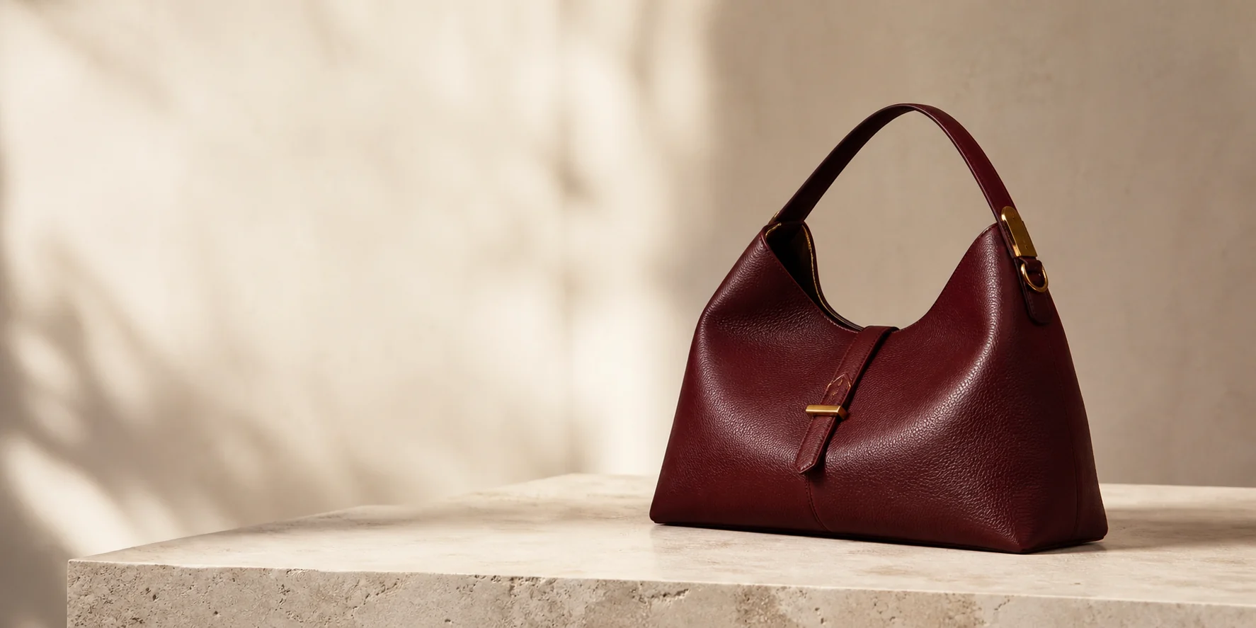 Oxblood leather bag in a warm stone studio